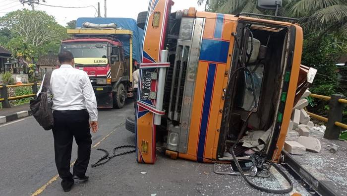 Truk Muatan 30 Ton Hebel Hantam Pembatas Jalan hingga Terguling di Tabanan
